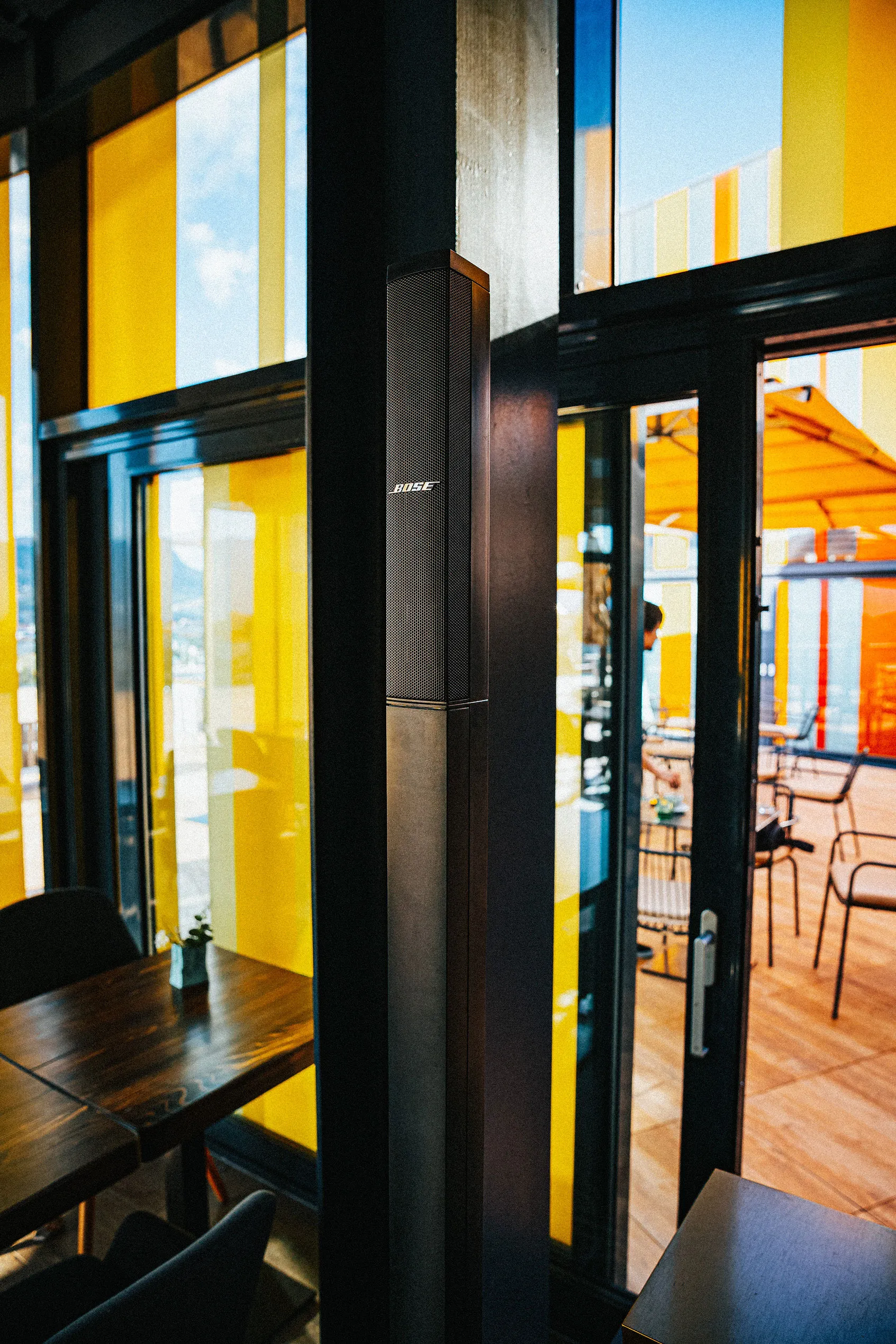 Bose column speaker installed in a restaurant interior blending with the venue design — Cosmic Production AV integration