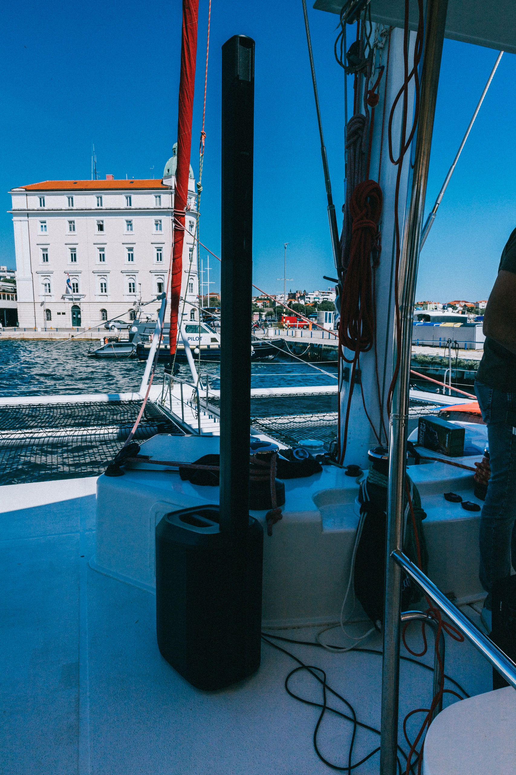 Bose column speaker set up on catamaran deck with Split waterfront buildings behind