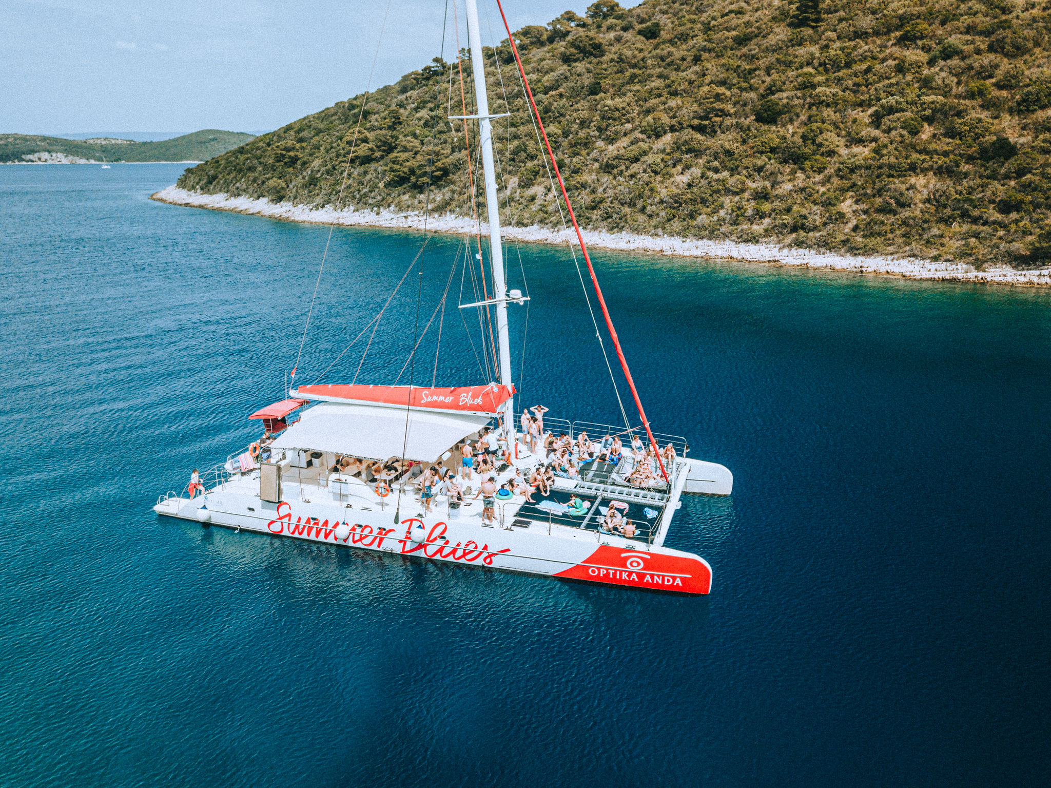 Catamaran anchored in crystal turquoise water off Hvar