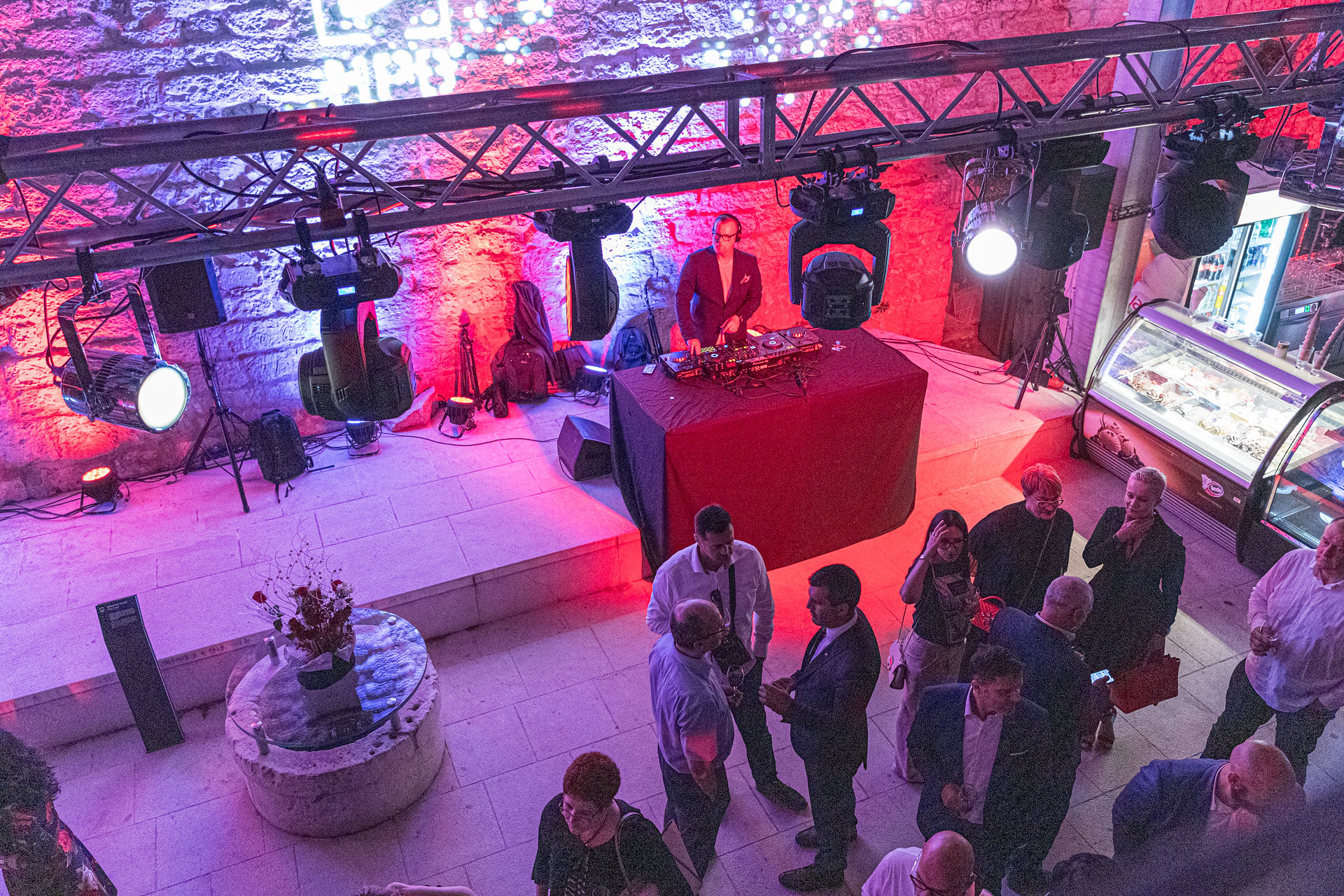Overhead view of DJ booth and full production lighting rig at corporate fortress event