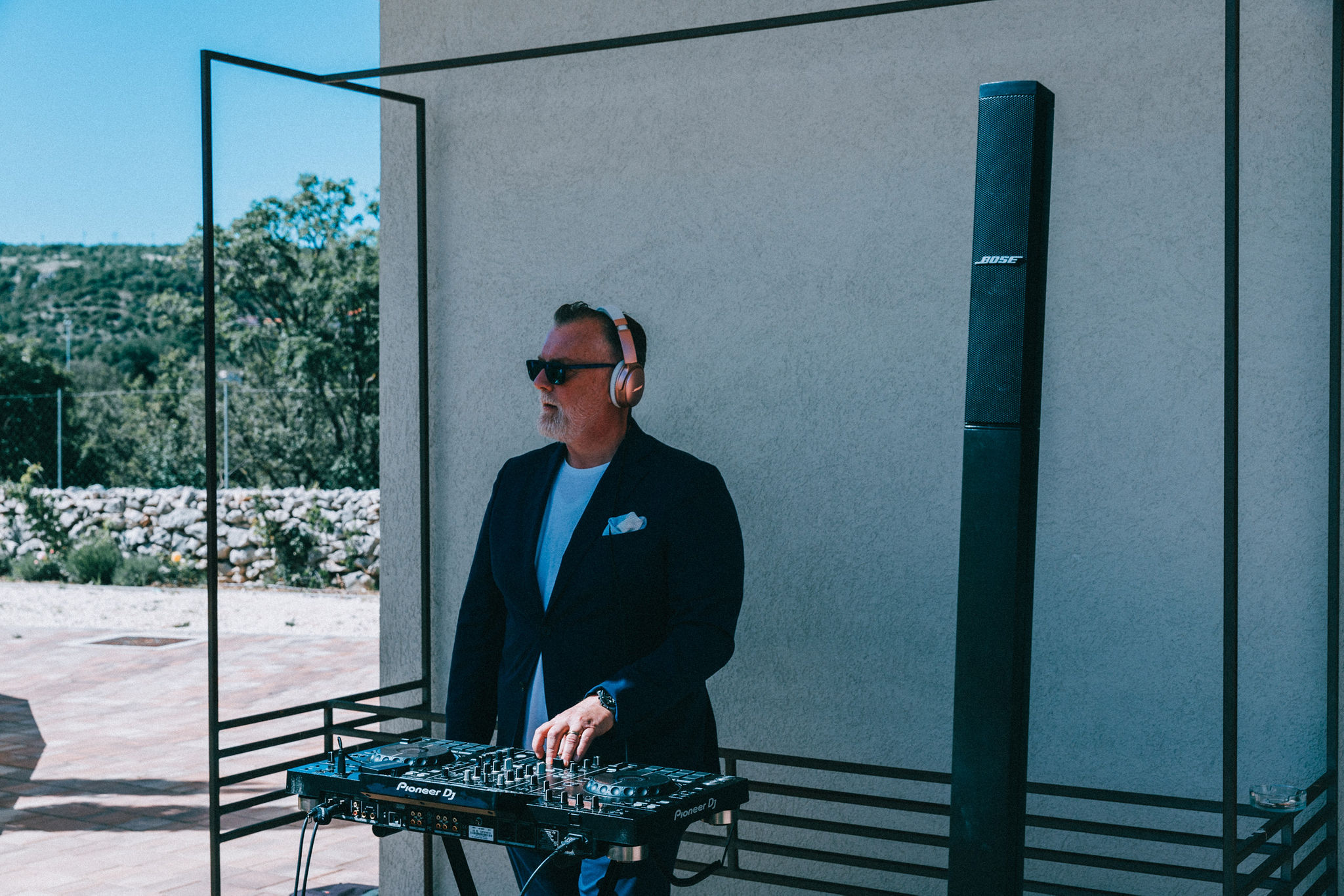 DJ performing at Pioneer controller with Bose column speaker at outdoor villa venue — complete event audio setup by Cosmic Production