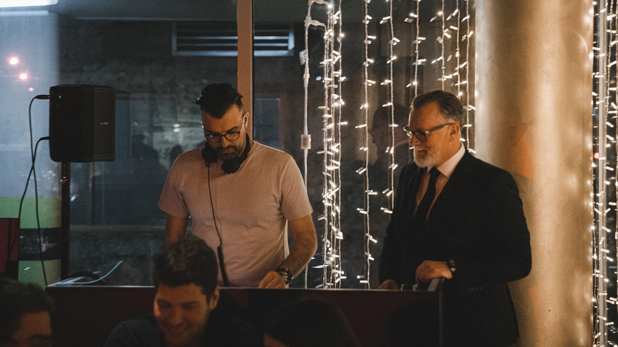 DJ Lomax and Matthew Bee performing a B2B set at Bokamorra restaurant in Split with fairy lights — Cosmic Production