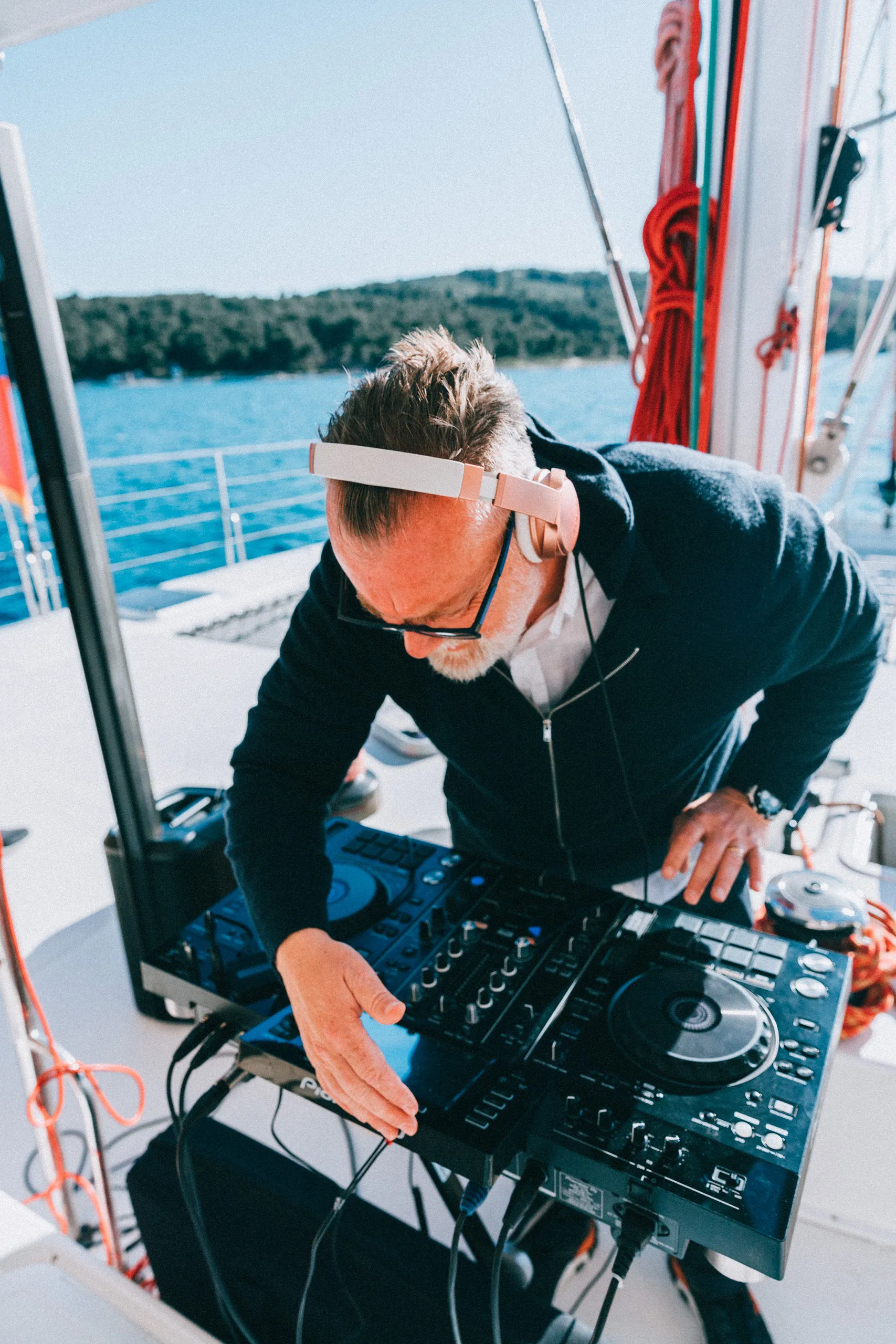 DJ Matthew Bee mixing on Pioneer DJ on a yacht deck — Cosmic Production
