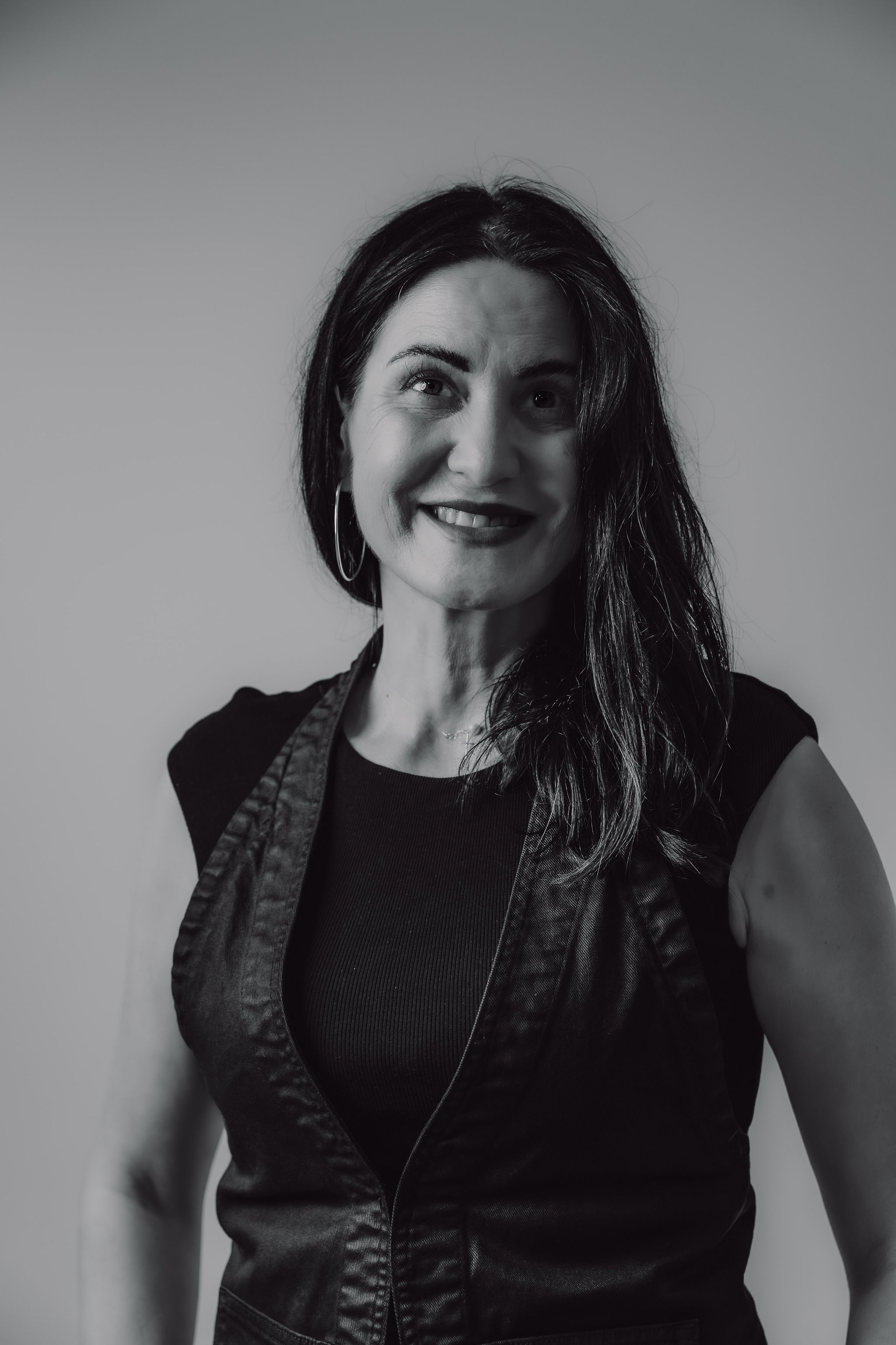 DJ Zhezha confident portrait, female DJ in leather vest from Cosmic Production