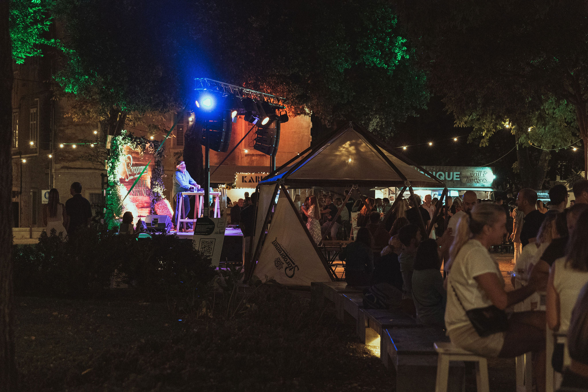 Festival stage with line array speakers, DJ, and crowd in Split