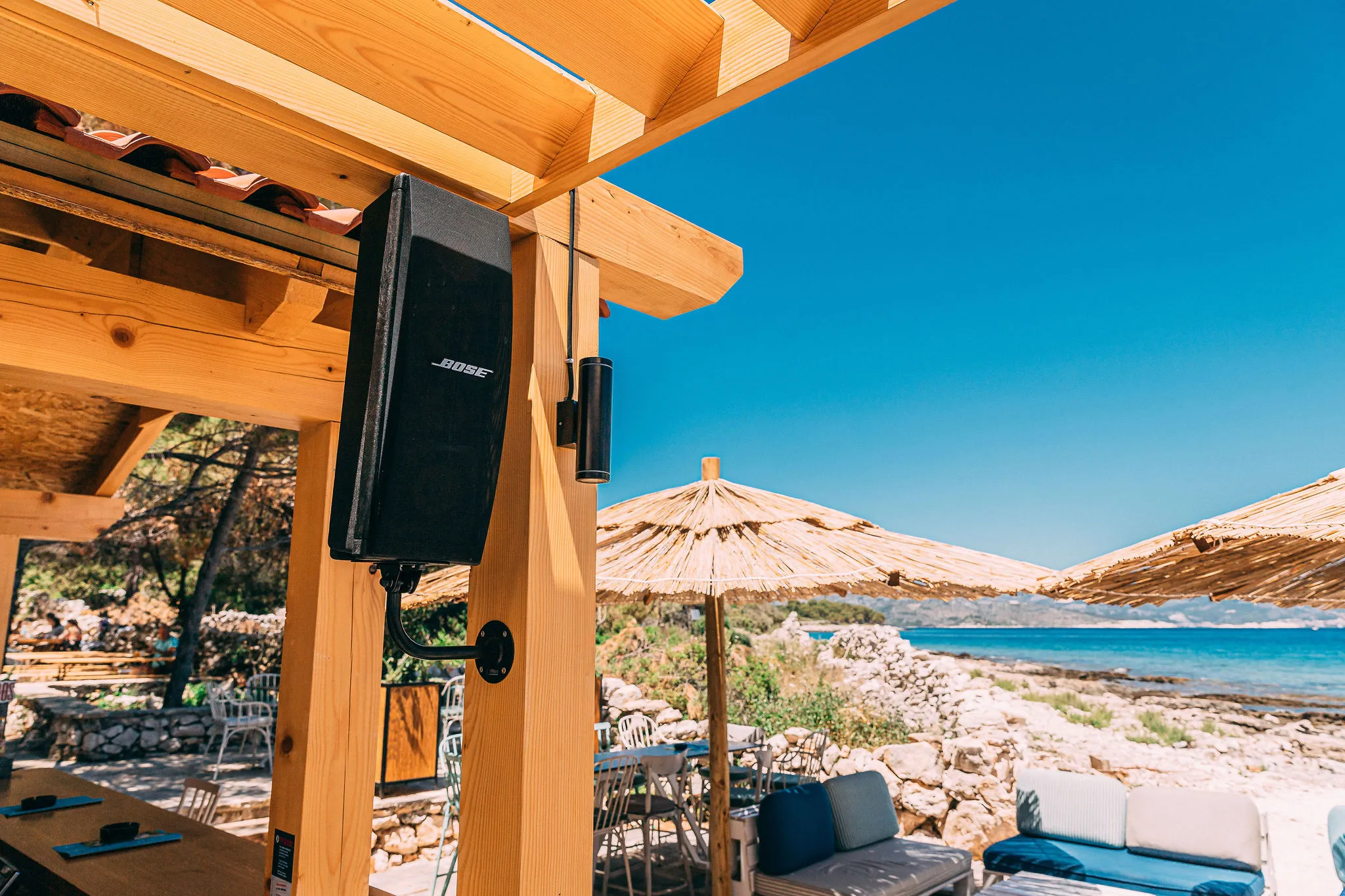 Bose speaker at Haven Beach Bar with Adriatic views and straw umbrellas — Cosmic Production AV