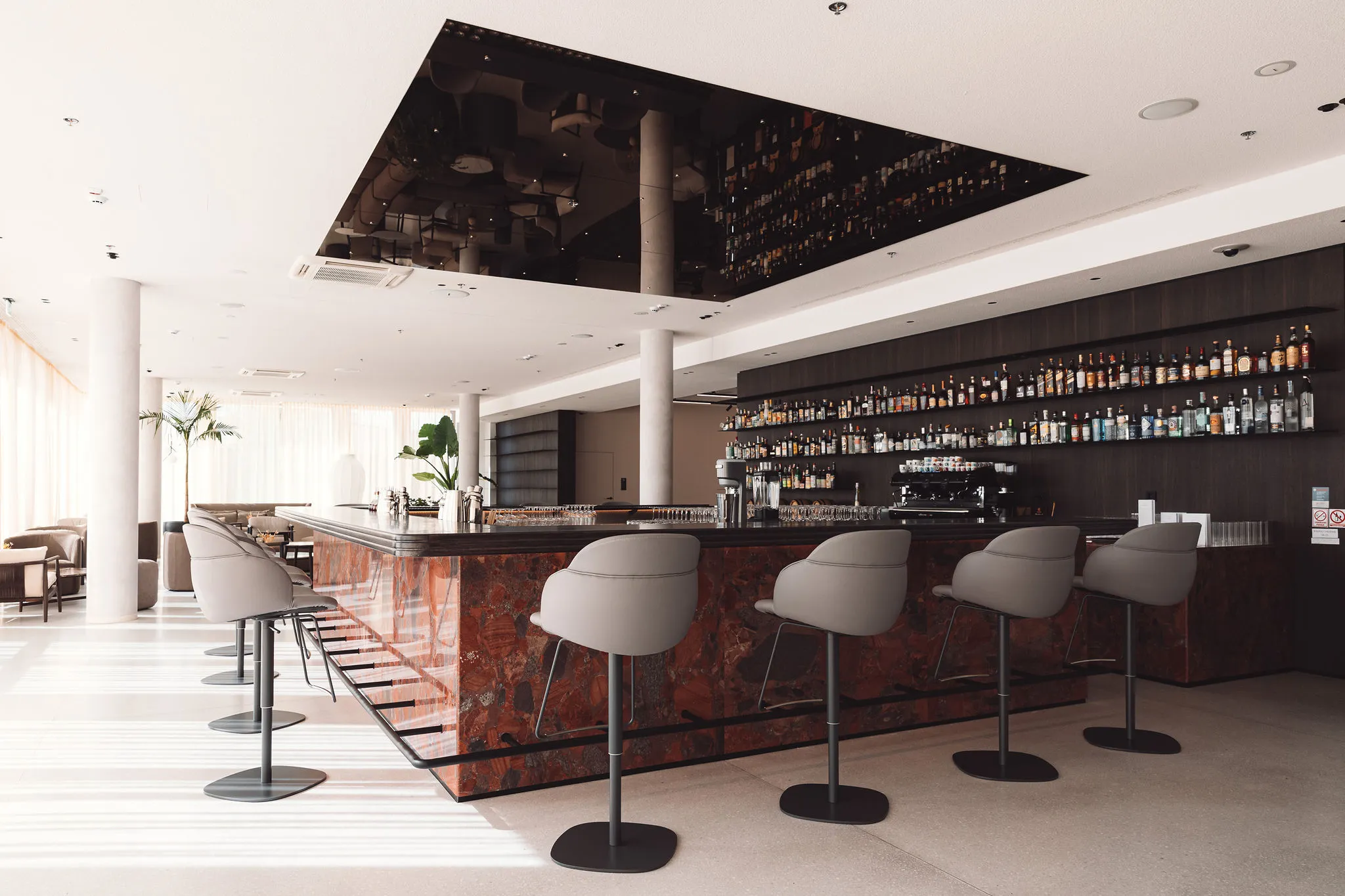 Hotel bar interior with red marble and Bose speakers — premium AV installation