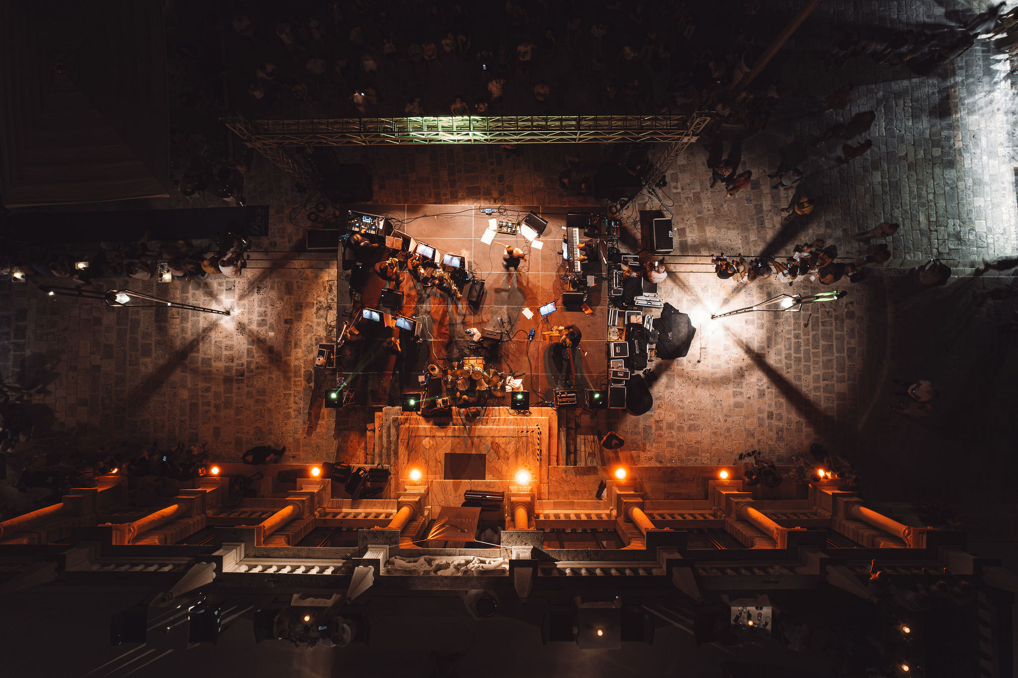 Overhead aerial view of stage truss, speakers, and monitor setup at night concert on Hvar