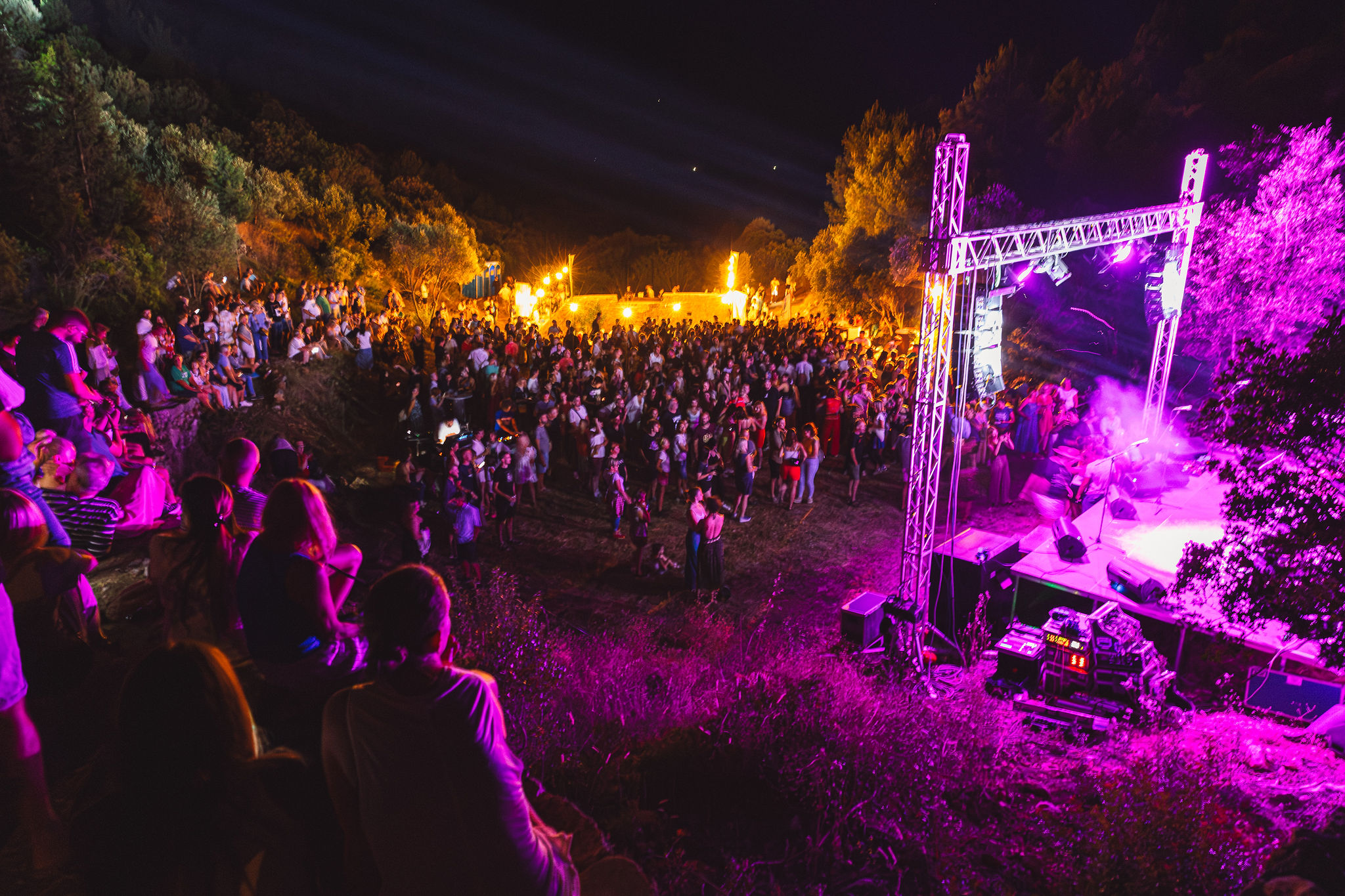 Wide elevated shot of outdoor concert at Lavender Festival with purple stage lighting and massive crowd on Hvar